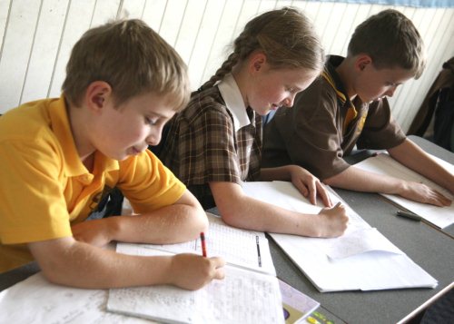 students writing in books at desk